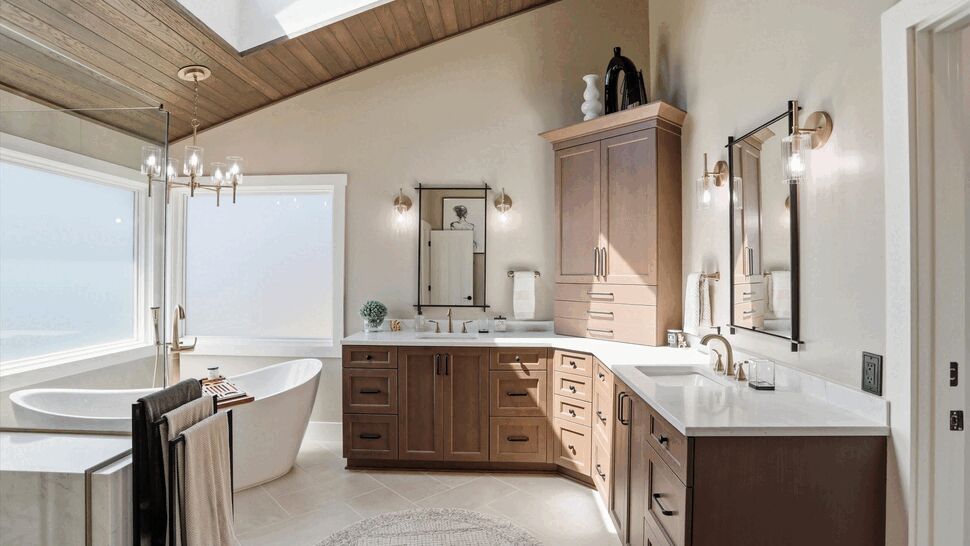 Wood vanity with double sinks and drawers next to a freestanding tub.