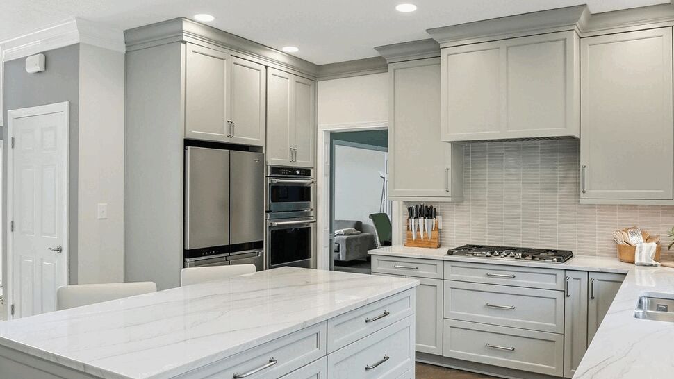 Kitchen island with marble top and warm hardwood flooring