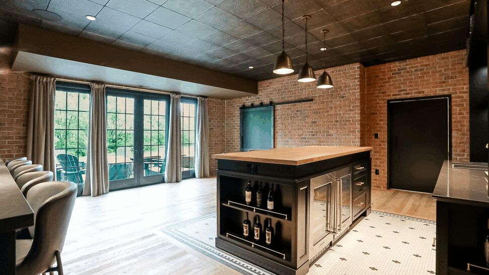 Spacious kitchen with central island, brick walls, and wood floors.