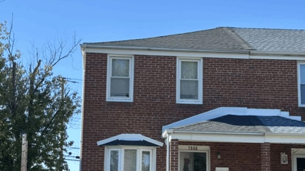 Brick Home With Gray Roof | Atlas Exteriors Brick home with gray shingle roof, white windows, and tall chimney.