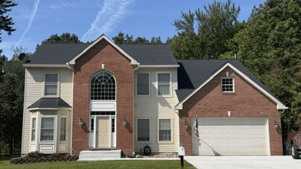 Front-facing home with new shingle roof | Atlas Exteriors Two-story brick and siding house front with dark shingle roof