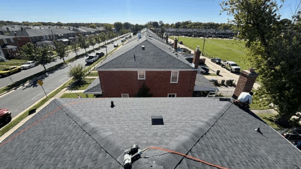 Completed Gray Shingle Roof | Atlas Exteriors Aerial view of a completed gray shingle roof over a brick home.
