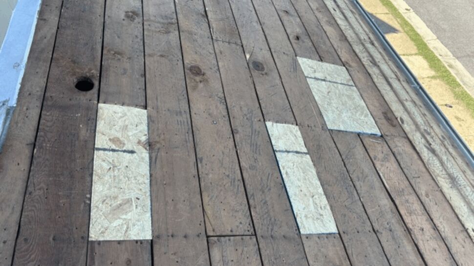 Damaged Roof Decking Repair | Atlas Exteriors Exposed roof decking with patched sections and surface damage