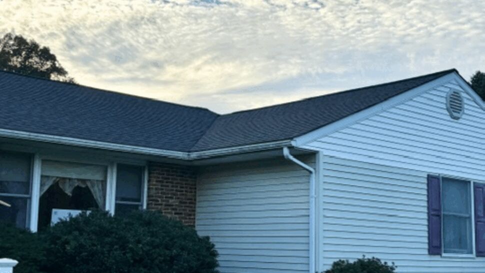 Gable Roof and Siding Exterior | Atlas Exteriors Close view of a home with a dark roof, white siding, and landscaped walkway.
