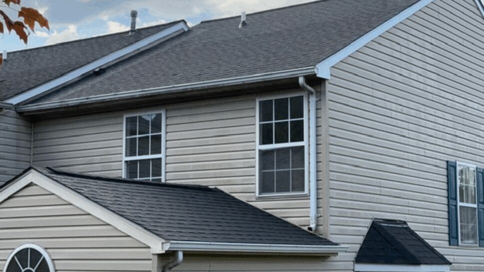 Gray-sided home with shingle roofing and white gutters.