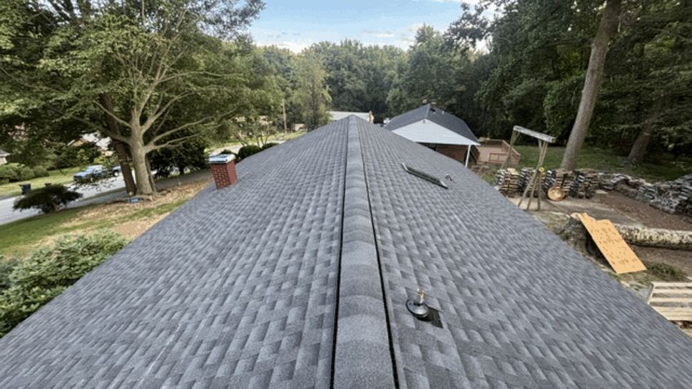 Long rooftop ridge with new grey asphalt shingles