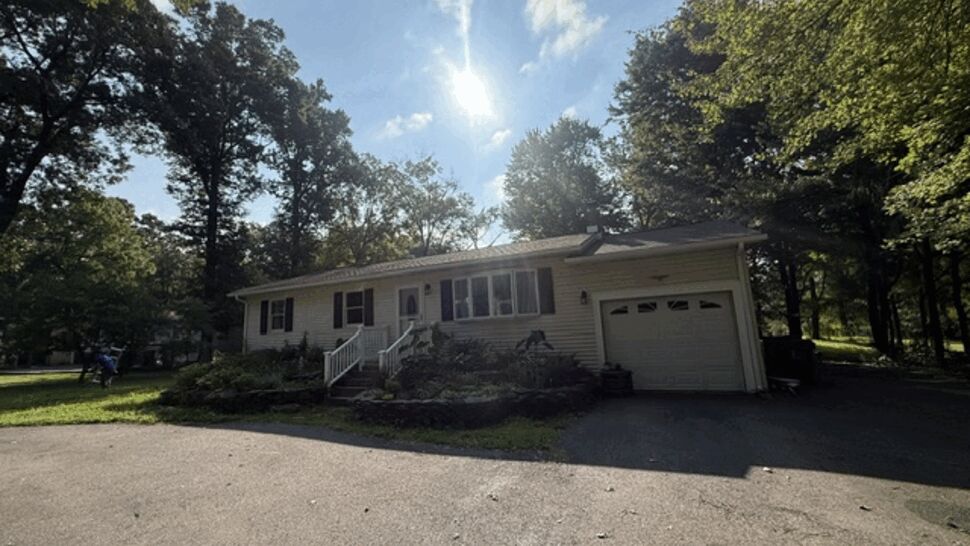 Front of single-story home with asphalt roof, siding, and attached garage.