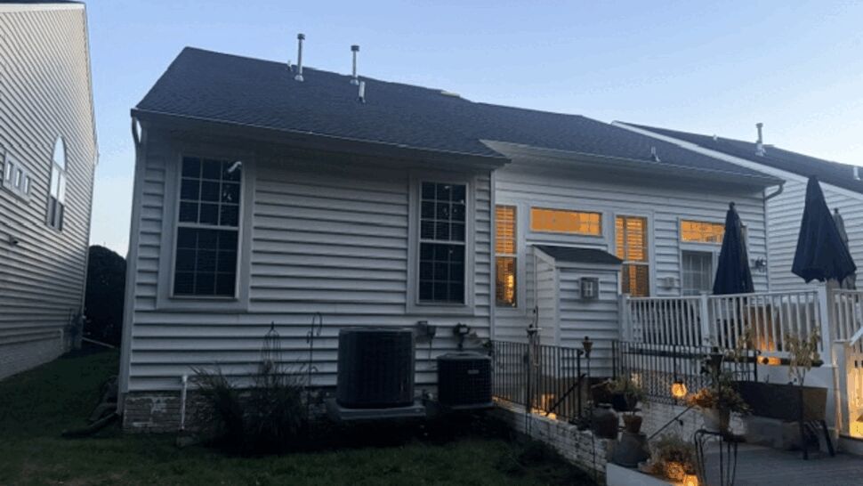 Back deck with white vinyl siding and roof work visible above.