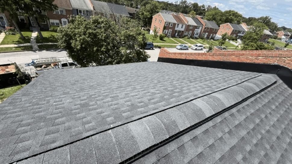 Residential roof with ridge vent | Atlas Exteriors Wide view of a residential shingled roof with a ridge vent overlooking a neighborhood.