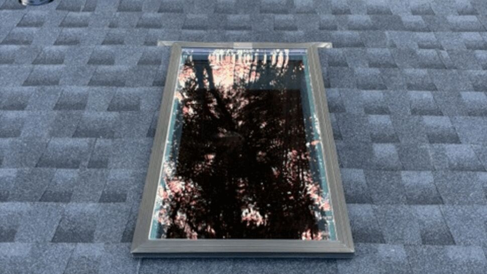 Skylight installed in grey shingle roof