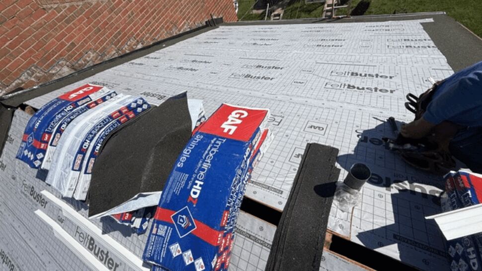Roofing supplies on prepared roof deck | Atlas Exteriors Roofing materials and starter shingles laid out on synthetic underlayment ready for installation.
