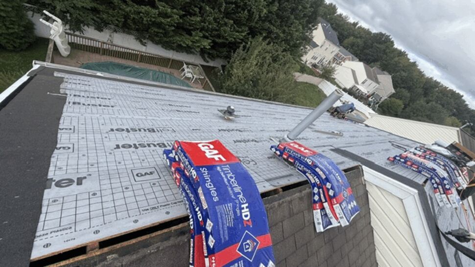 Rooftop underlayment with stacked shingle bundles ready for installation