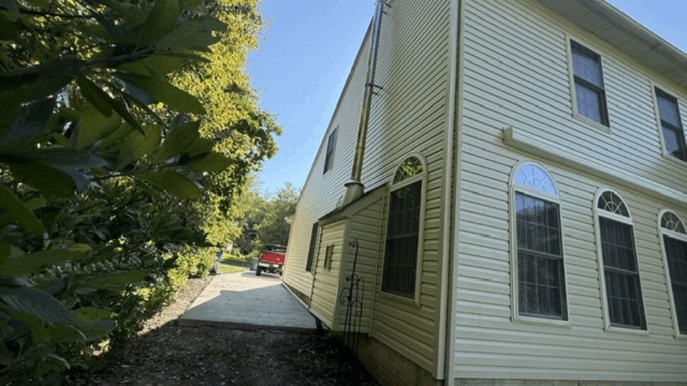 Closeup of house side showing downspout, gutter and vinyl siding detail