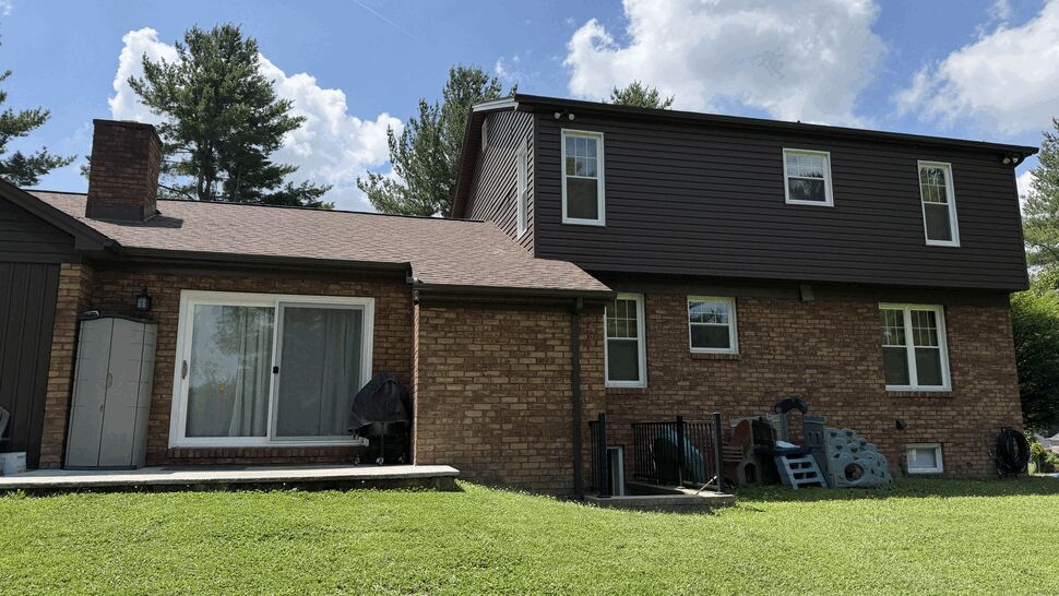 Side view showing brown siding, sliding door, and roofline