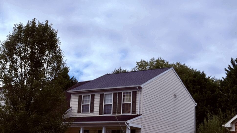 Two-story beige house showing vinyl siding and front windows