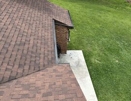Aerial view of shingled roof and gutter along patio edge