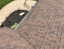 Close-up of asphalt shingles and roof valley near a concrete slab