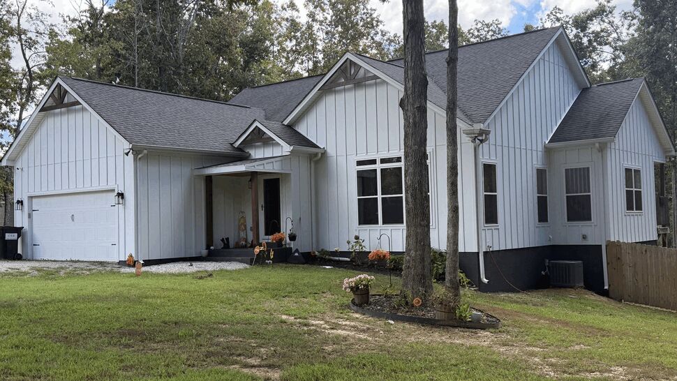 Complete Home Exterior Renovation | DominionX Wide view of a white home with multiple gables, dark roof, and landscaped yard.
