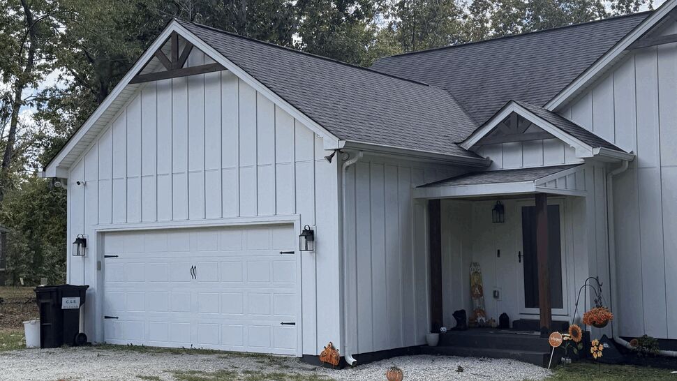 White Home with Shingle Roof | DominionX White home with dark shingle roof, garage, and front entry.