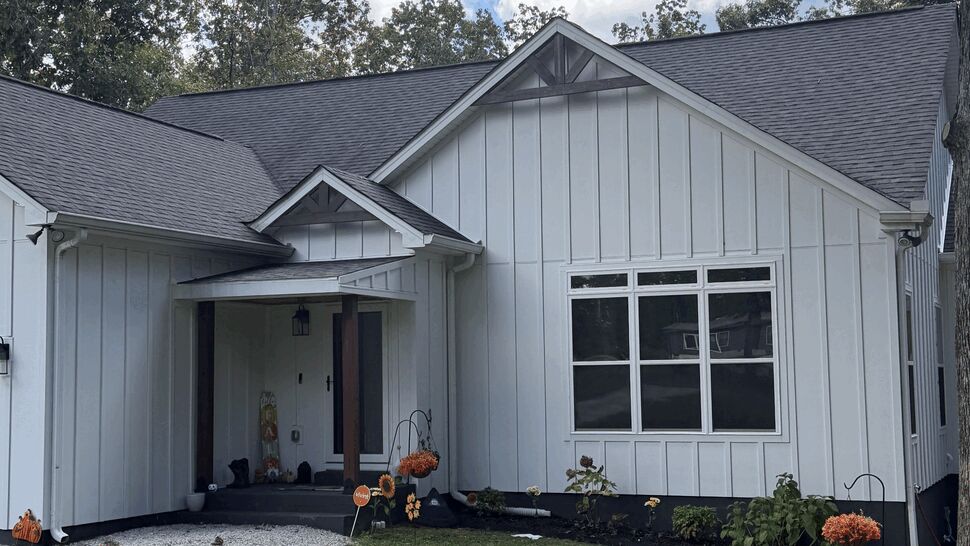 White Siding Front Elevation | DominionX Front elevation of a white home with vertical siding and large windows.