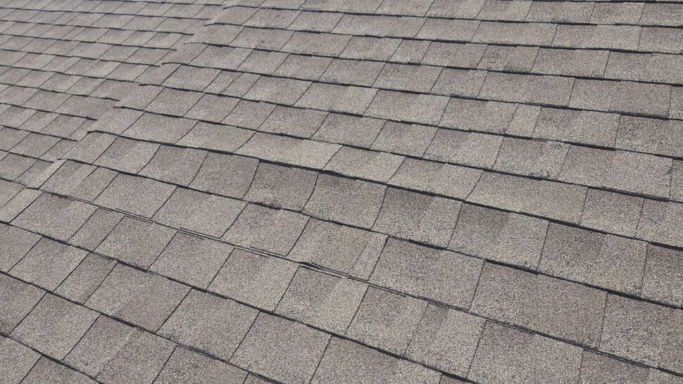 Detailed close-up of weathered asphalt shingles on a sloped roof