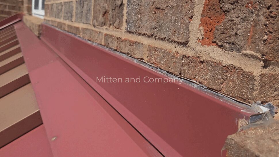 Sealed Brick Roof Flashing | Mitten & Company Close-up of roof flashing sealed against a brick wall