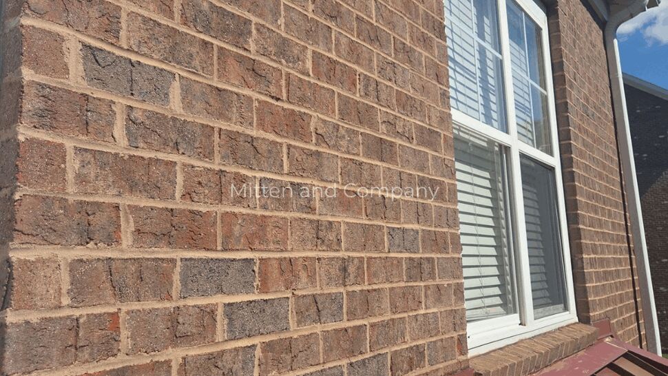 Brick Wall Roof Flashing | Mitten & Company Red metal roof flashing installed along a brick wall and window