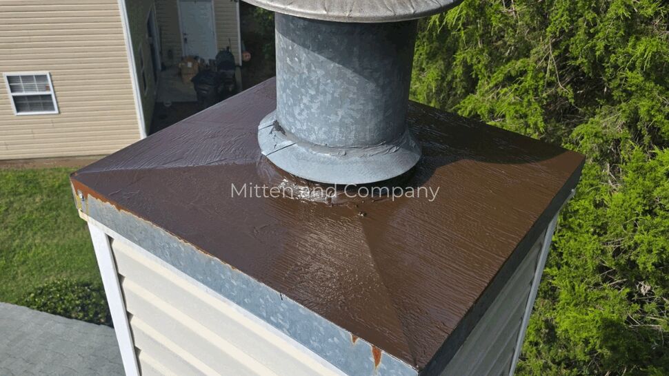Chimney cap and flashing inspection | Mitten & Company Close-up of chimney cap and metal flashing with visible sealant and edge rust