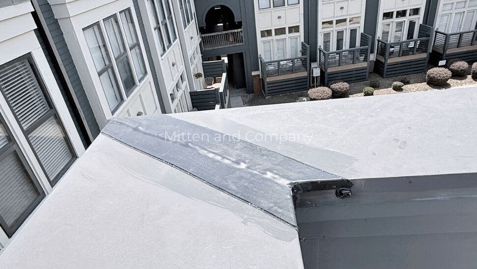 Roof Seam Repair Detail | Mitten & Company Close-up of sealed roof seam on parapet with apartment buildings beyond
