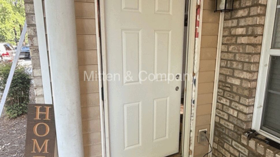 White exterior door removed from its frame on a porch during repair work.