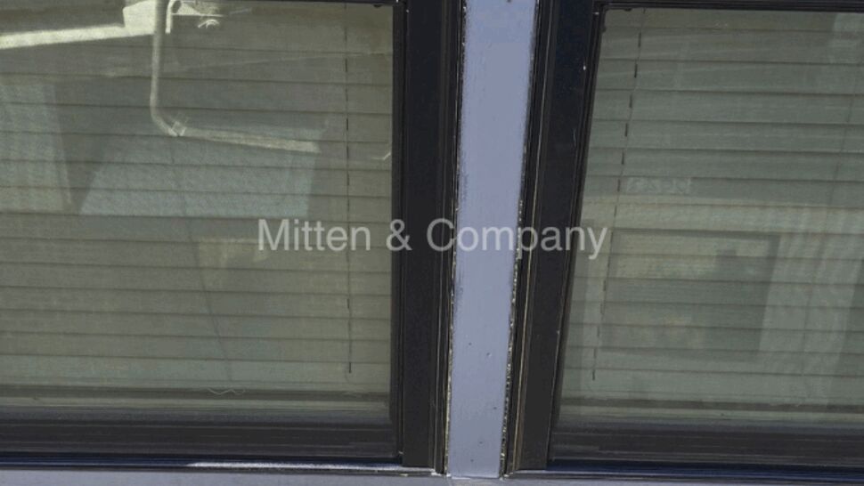 Two windows with painted trim and white siding exterior