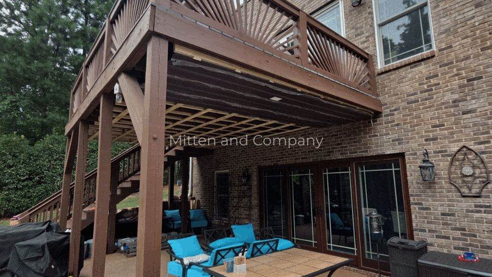 Elevated Backyard Deck | Mitten & Company Elevated wooden deck beside a brick home with outdoor furniture