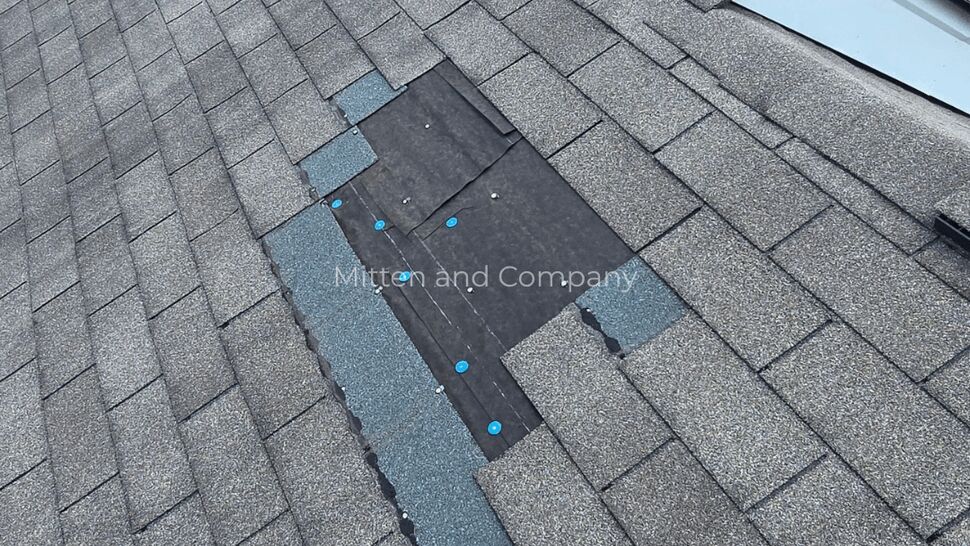 Exposed Roof Underlayment | Mitten & Company Gray shingle roof with a large exposed underlayment section near the ridge