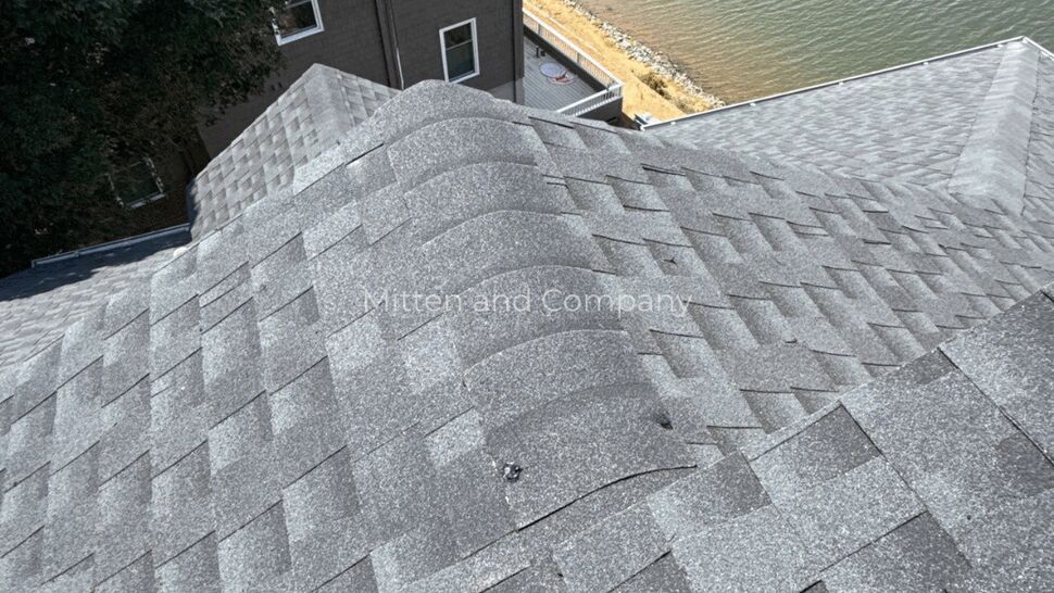 Gray Asphalt Shingle Roof on Multifamily Building | Mitten & Company Aerial view of gray asphalt shingle roof ridge on a multi-story waterfront building