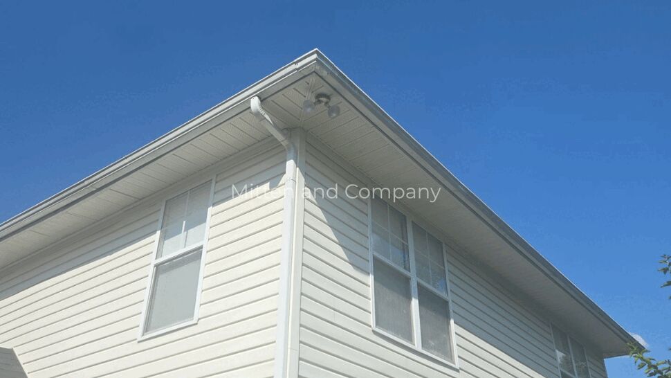 Wide angle of house corner showing siding, windows, and soffit