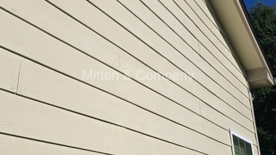 Beige siding on a house exterior with a window and eaves