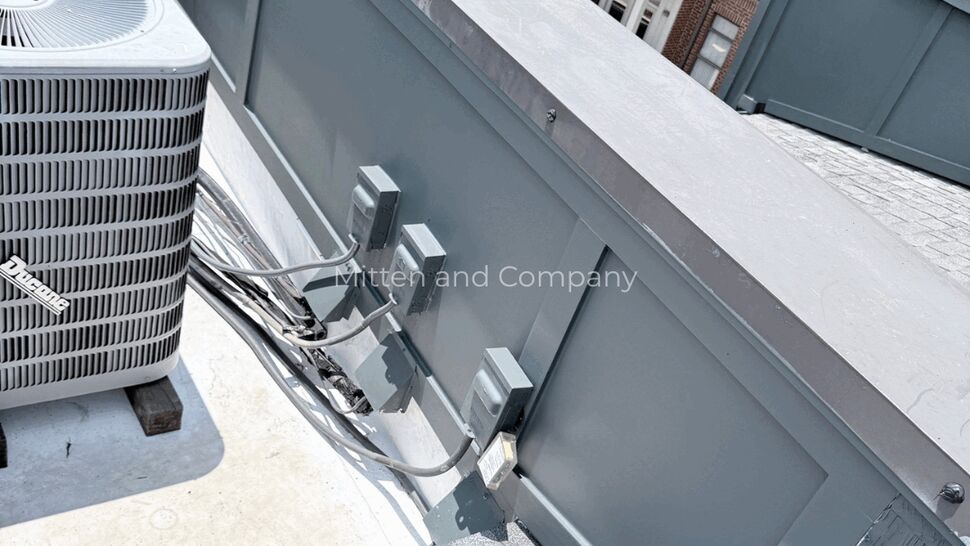 HVAC Electrical Roof Detail | Mitten & Company Electrical disconnects and conduit mounted along parapet next to an AC unit