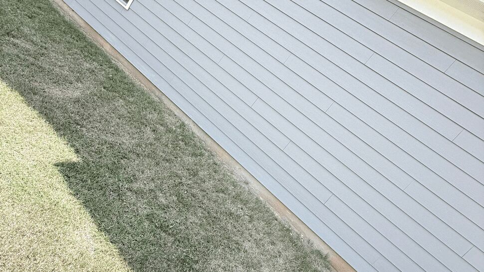 Long exterior siding panels with a small window and foundation