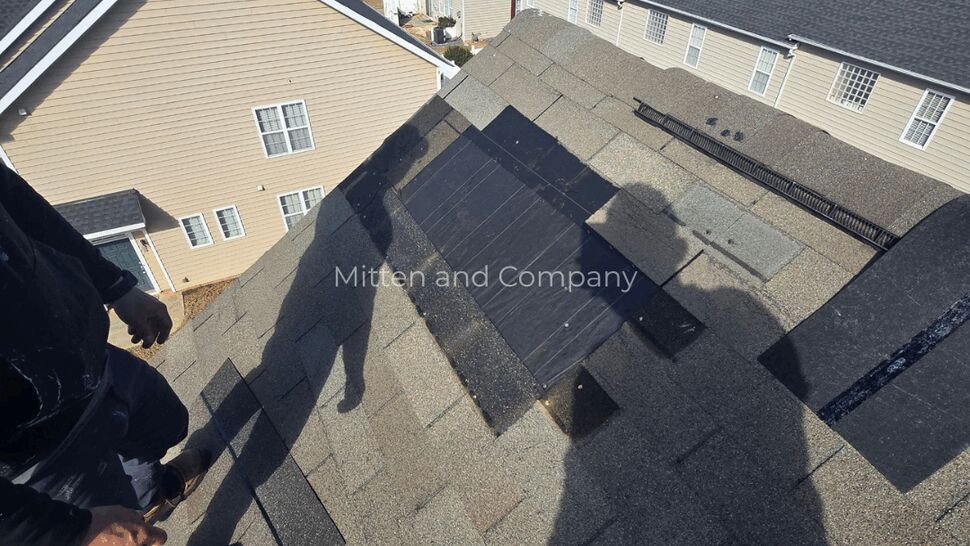 Multifamily Roof Inspection | Mitten & Company Worker inspecting shingle roofs across a multifamily housing community