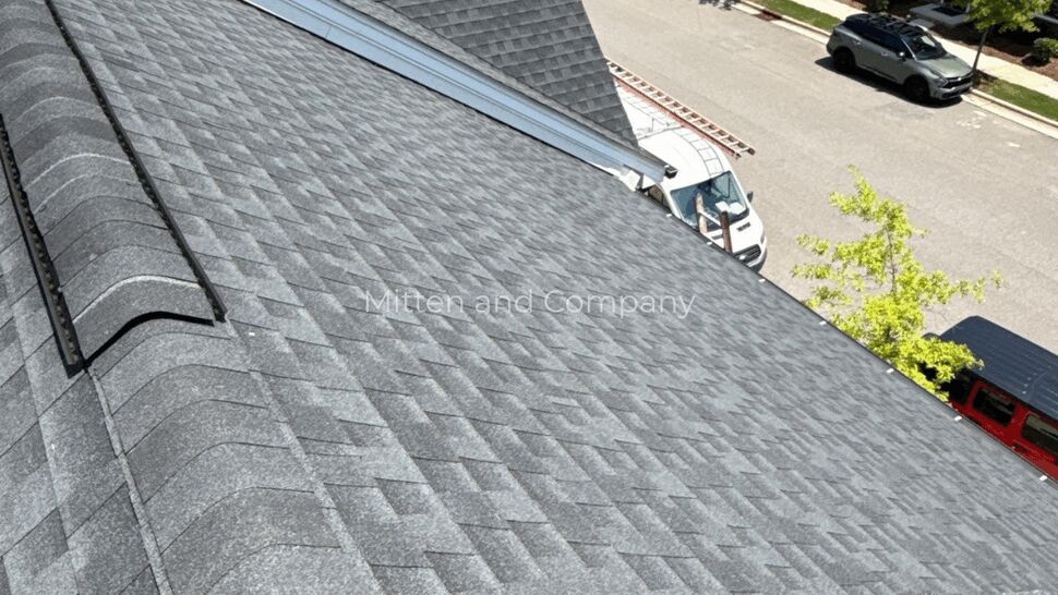 Close aerial view of gray shingles on a multifamily roof.