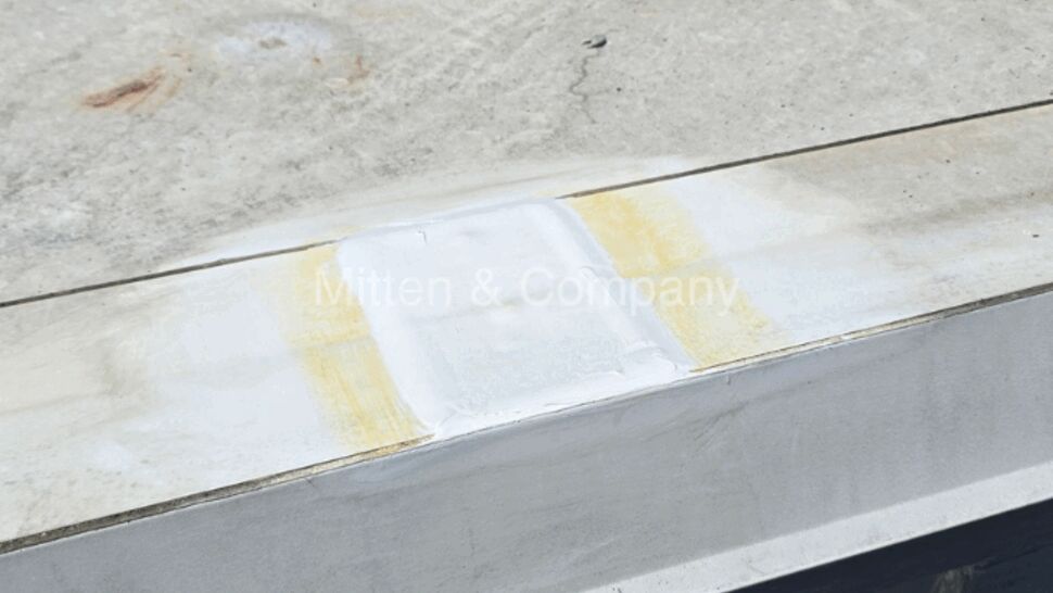 Sealed patch on parapet cap with surrounding staining