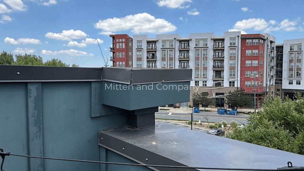 Parapet and rooftop view overlooking nearby multifamily apartment buildings