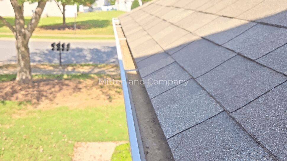 Residential Roof and Gutter Line | Mitten & Company Residential shingle roof and gutter running along a landscaped front yard