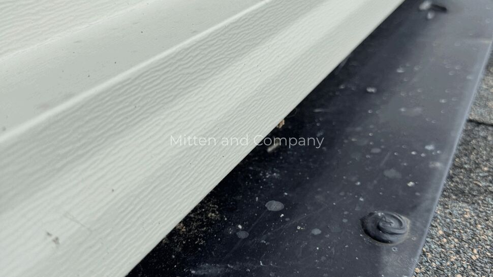 Roof flashing and fastener detail | Mitten & Company Close-up of roof flashing and sealed fastener on shingle roof