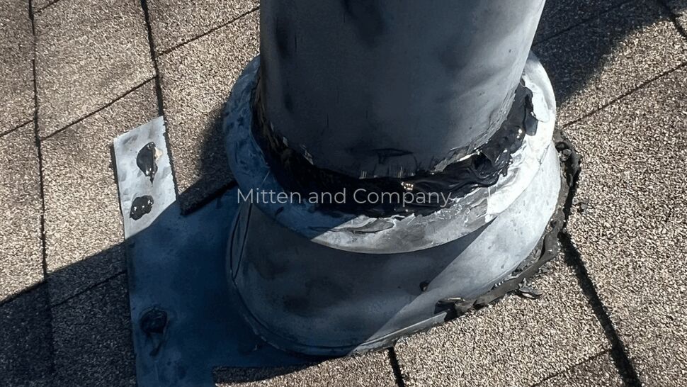 Close-up of a vent pipe boot and flashing on an asphalt shingle roof