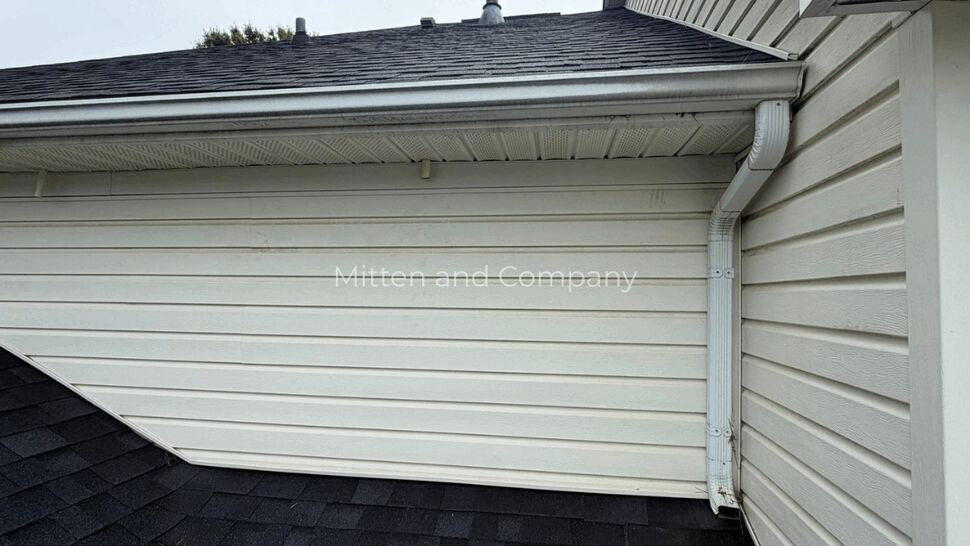Residential Roofing and Siding Inspection | Mitten & Company Residential roof, siding, soffit, and downspout viewed from an angle