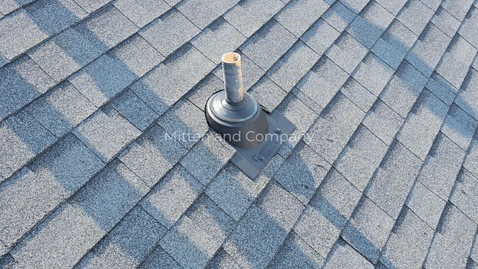 Close-up of a roof vent and flashing on gray asphalt shingles