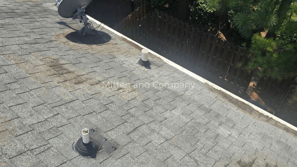 Close-up of roof vents and satellite mount on asphalt shingles