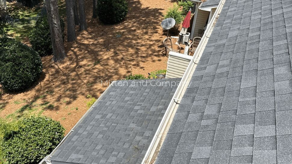 Wide view of main roof and small porch roof with gutters running the length
