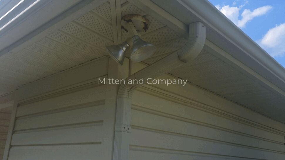 Roof soffit and corner gutter with downspout at house corner